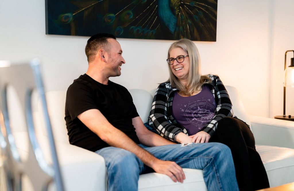 couple on couch smiling at each other